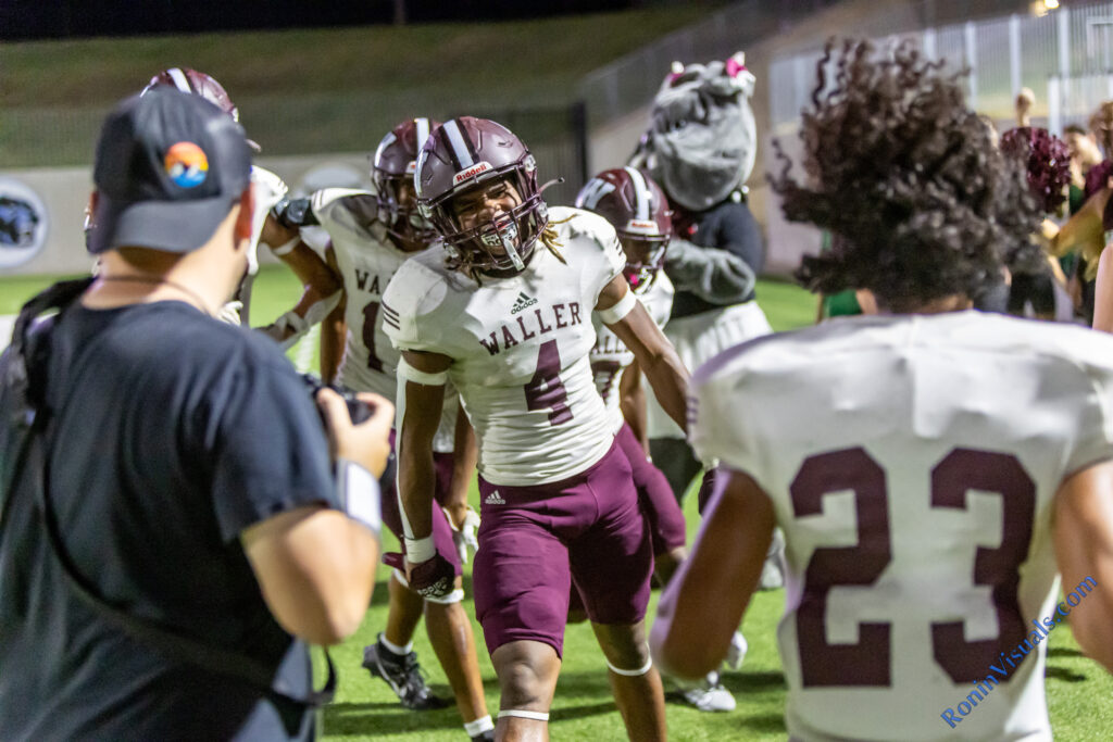 Brandon Stewart (4) celebrates a 30-yard touchdown pass from Jordan Duncan (not shown), putting the Bulldogs up, 28-0, with a pack of Waller players congratulating him on the play. The Waller Bulldogs break their losing streak with a victory over Katy Mayde Creek’s Rams, 35-0, at Legacy Stadium, Saturday, Sept. 2, 2023. (Photo courtesy RoninVisuals.com)